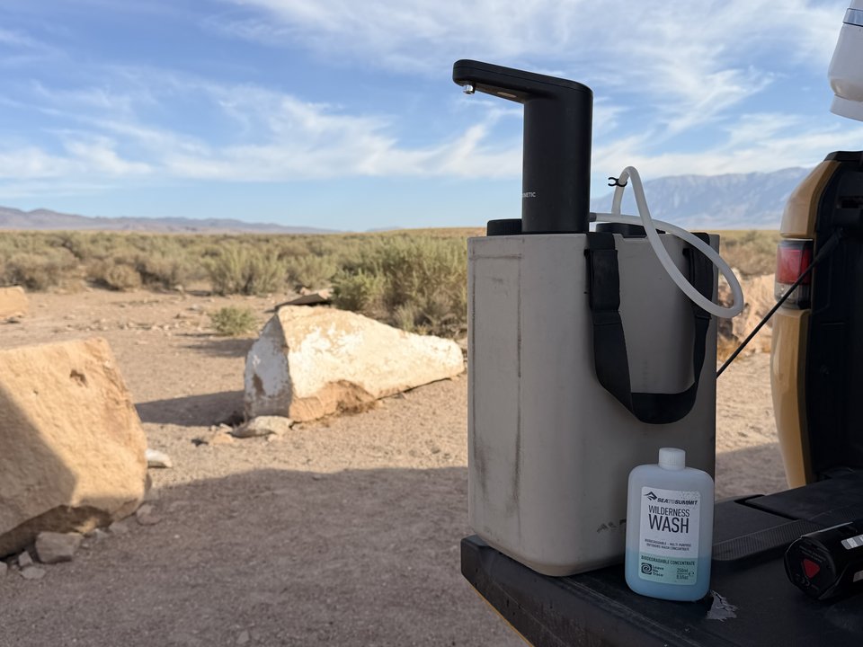 Dometic GO faucet mounted on its water jug at a desert campsite