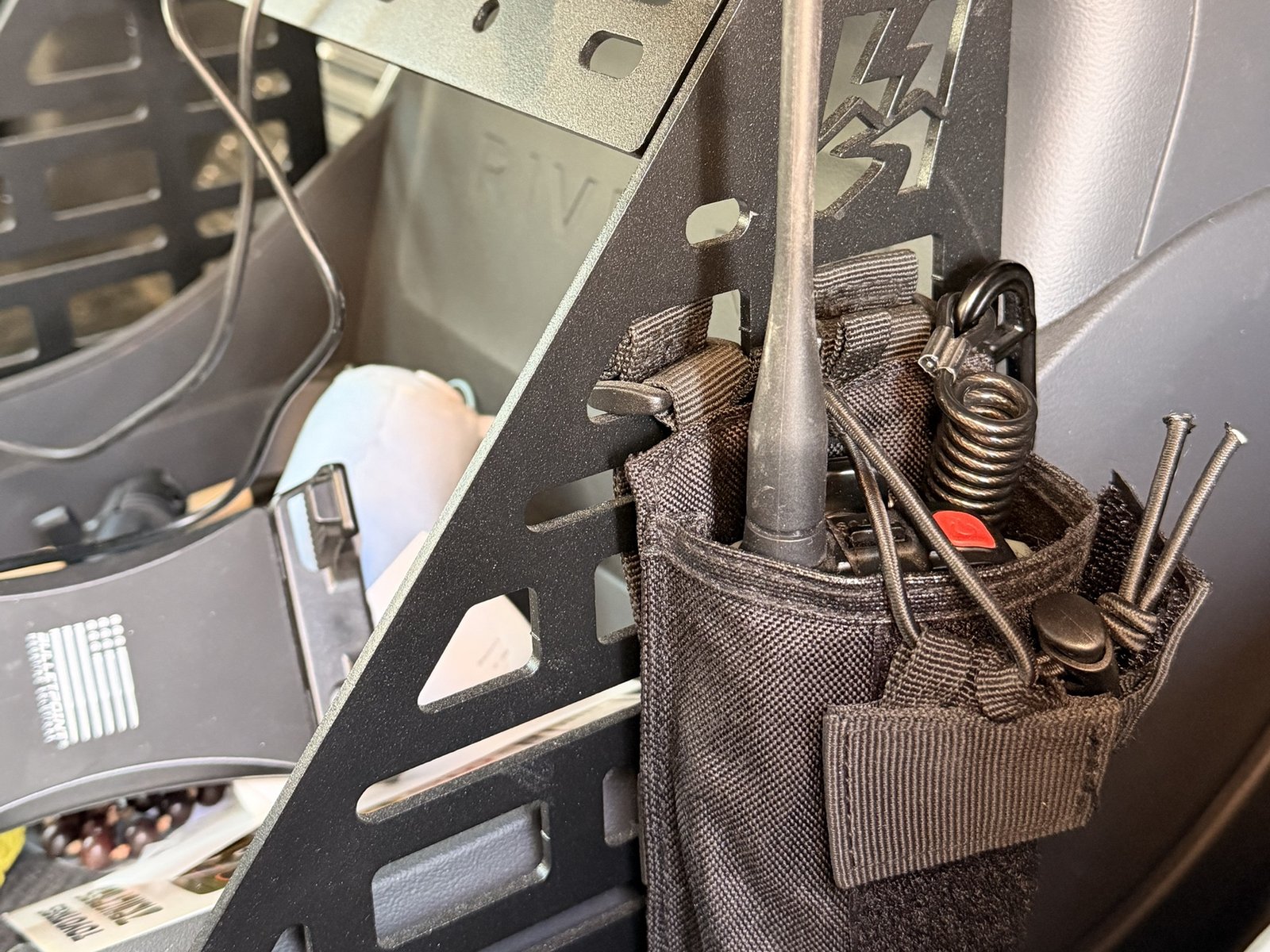 Radio pouch and gear mounted to the Electrified Overland MOLLE panel behind the seat
